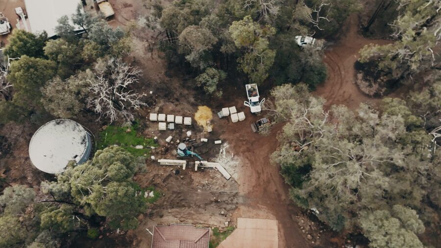 Aerial view of a large bush block with materials staged ready for the build